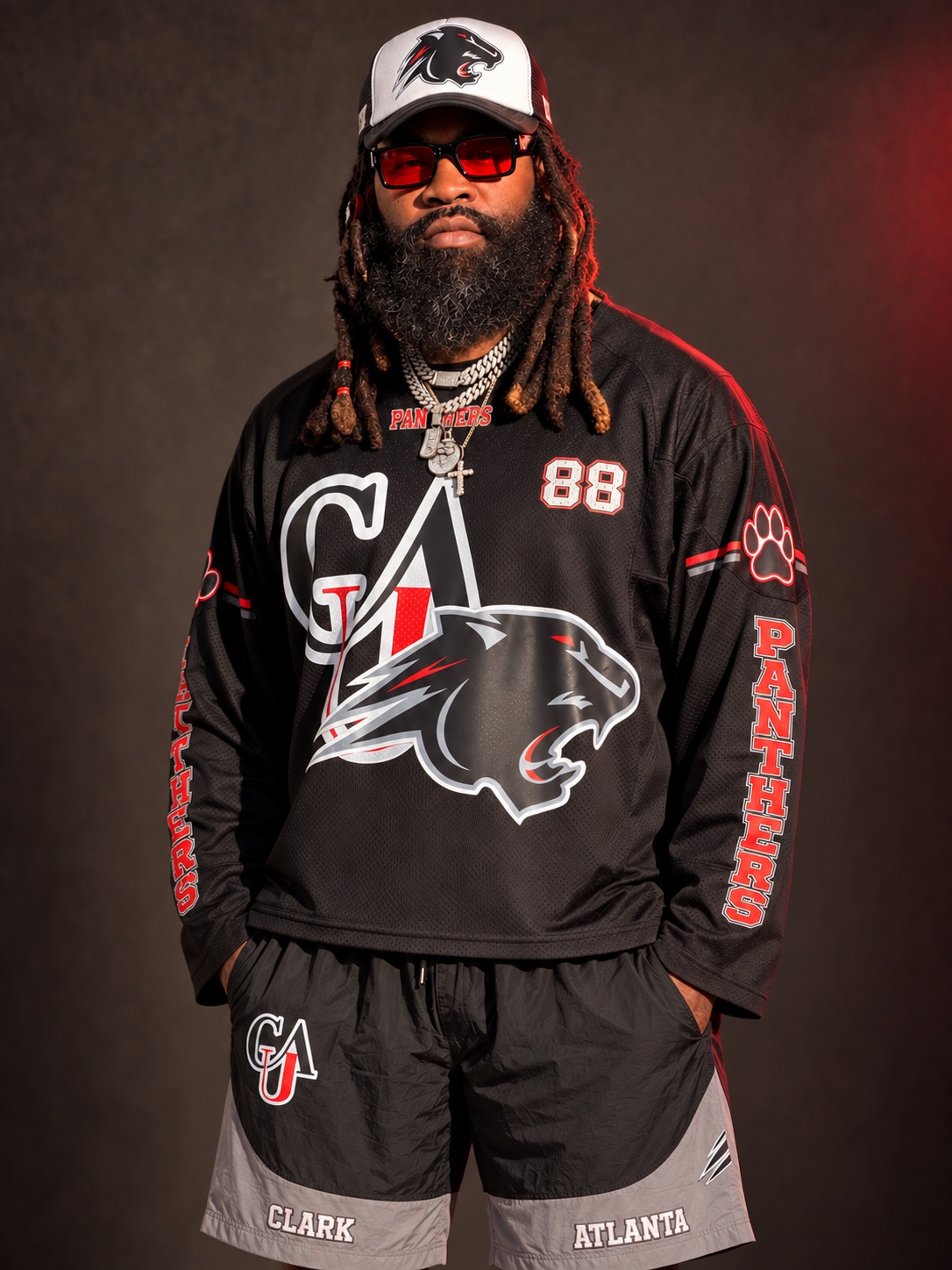 Chief wearing his Clark Atlanta 88 jersey, black and gray shorts, and Panther hat in a studio portrait
